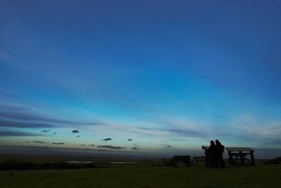 People looking out over Northward Hill reserve from Marshland Viewpoint at dusk