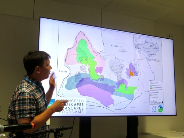 A person presenting in front of a large screen that is displaying a map of a 5 million hectare landscape in west Kazakhstan