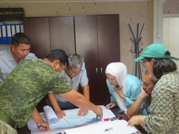 A group of people studying a map as part of the participatory mapping exercise