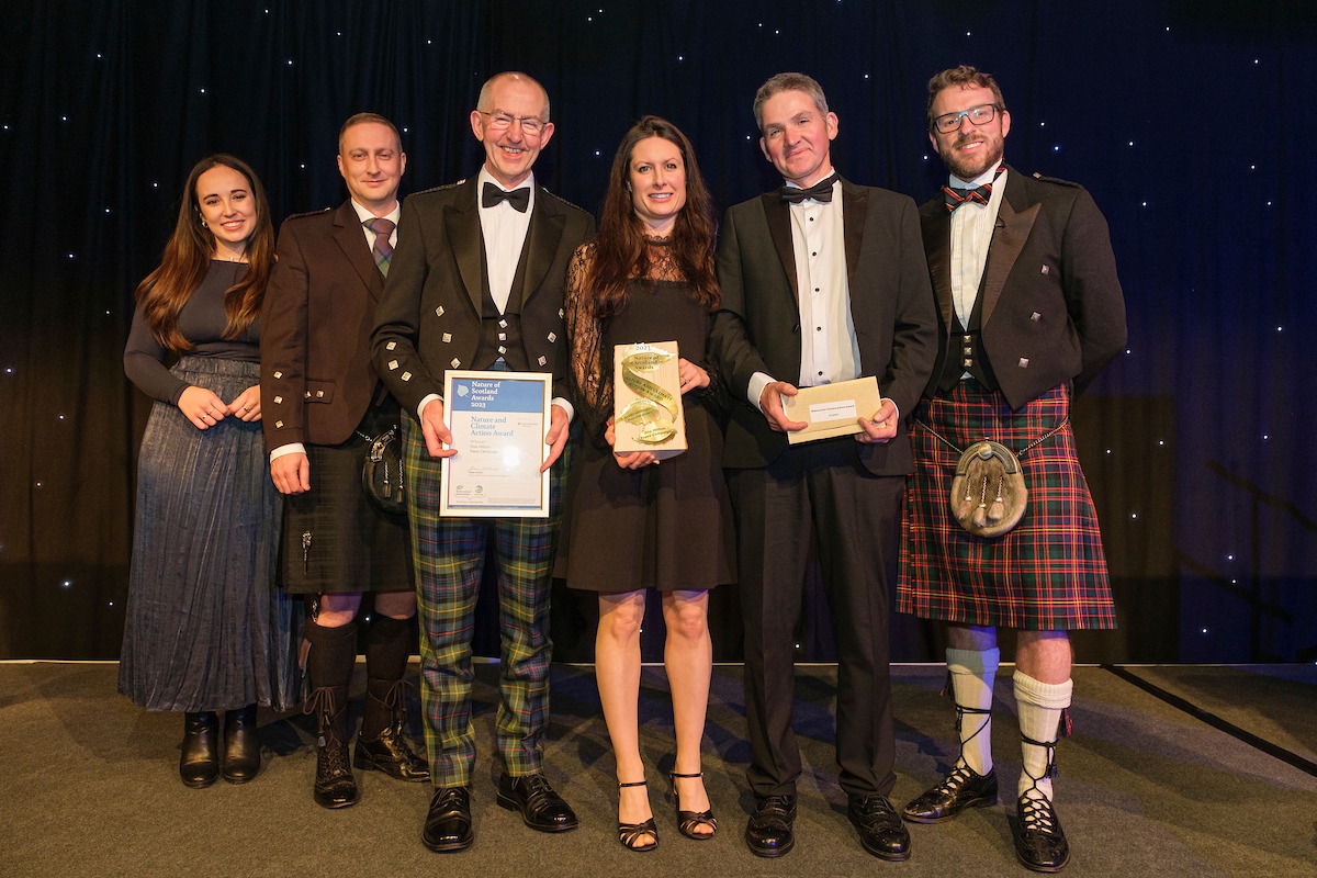 The winners of the 2023 Nature of Scotland Nature and Climate Award hold their trophies alongside hosts Megan McCubbin and JJ Dillon.