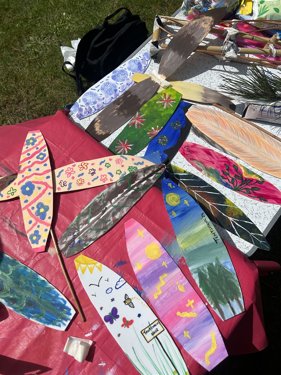 Various pieces of card decorated in various styles and cut into the shape of eagle feathers.