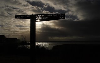 Dramatic winter sky over a signpost at Rainham Marshes nature reserve by Tony O'Brien