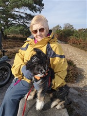 Jo's Mum sat on a bench with their dog at RSPB Arne 