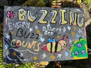 A colourful painted slate with the words 'Every buzz counts' on.