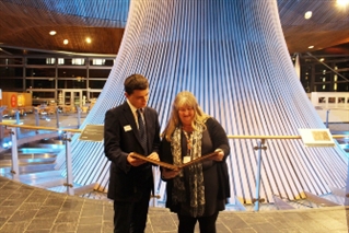 The Nature Positive Wales scrapbook is handed to Julie James MS in the Senedd.