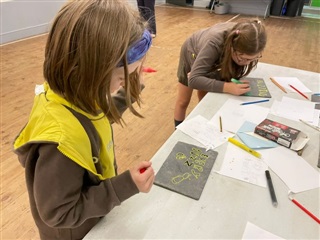 A group of brownies make slate signs for the Bilberry Bee campaign.