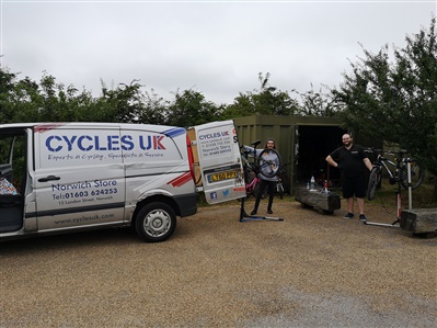 Two members of staff from CyclesUK have two of Rainham Marshes' bicycles on stands and are giving them a full service.
