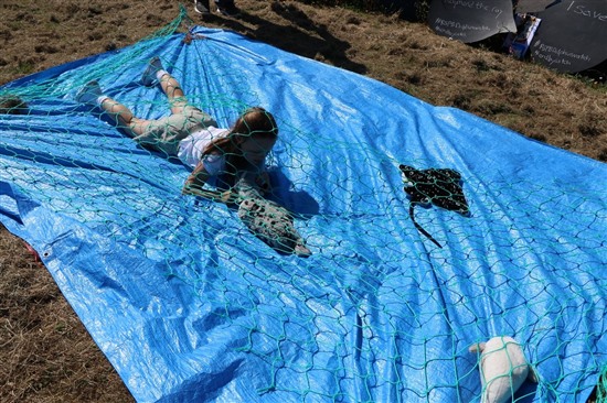 child climbs through netting on obstacle course
