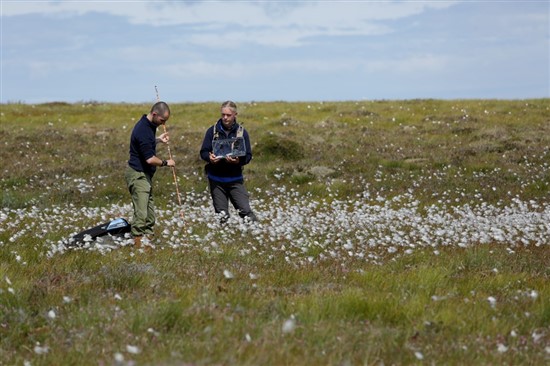 two people with peat monitoring instruments
