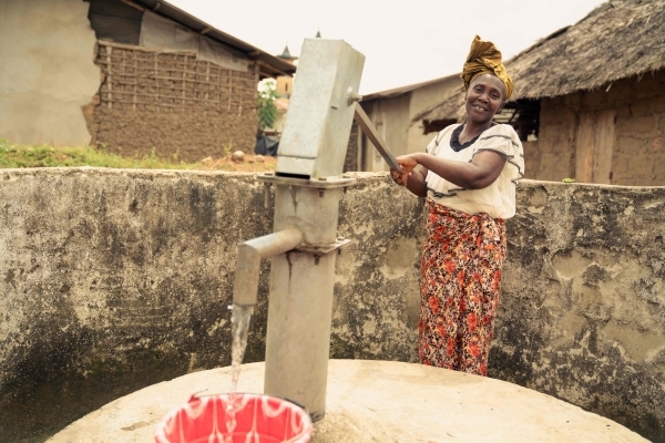 Local community member using a water pump installed in a forest-edge community
