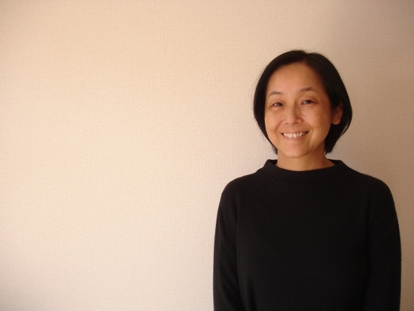 Yasuko Suzuki smiles for the camera against a plain background