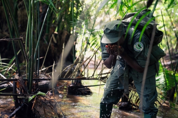 A ranger washes their face while on patrol in Gola Rainforest