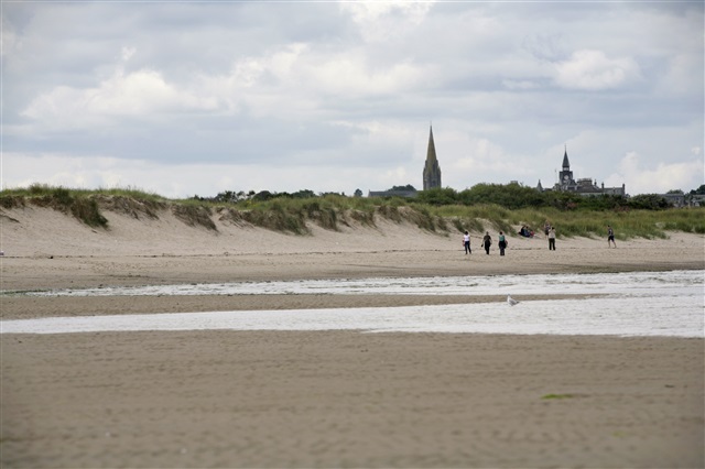 view of a beach with people walking along it