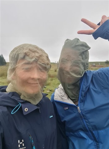 Two volunteers with midge nets over their faces.
