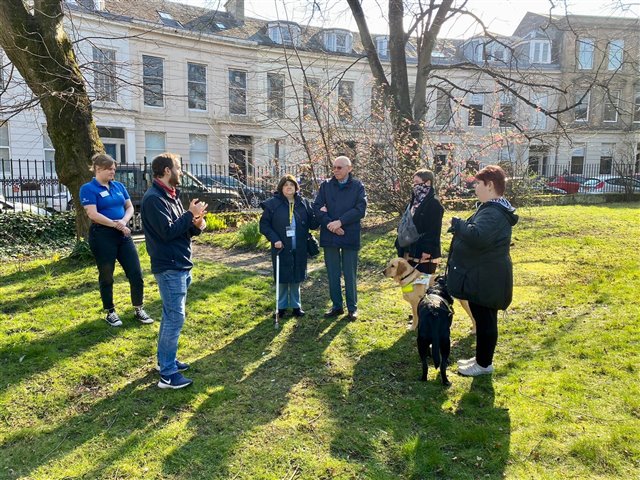 RSPB Scotland's David Anderson and Colleen Turner are discussing bird calls with service users of Visibility Scotland in the garden at Queen's Crescent.