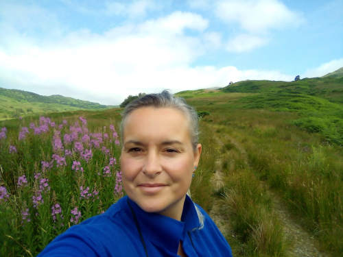 Ranger Louise with flowers and hills in the background
