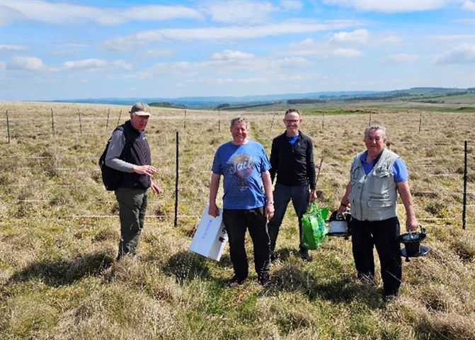 Image shows a group of four male volunteers in the Northumberland landscape